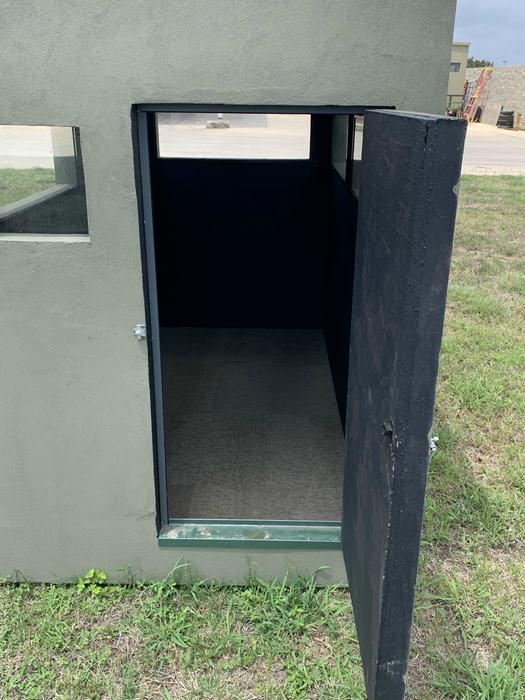 Deer blind door open at ground level, showing the carpeted floor and interior